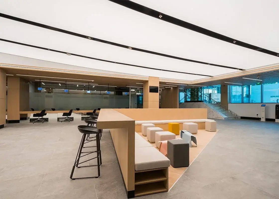 Open plan office with a seating area & LED strip ceiling lights.